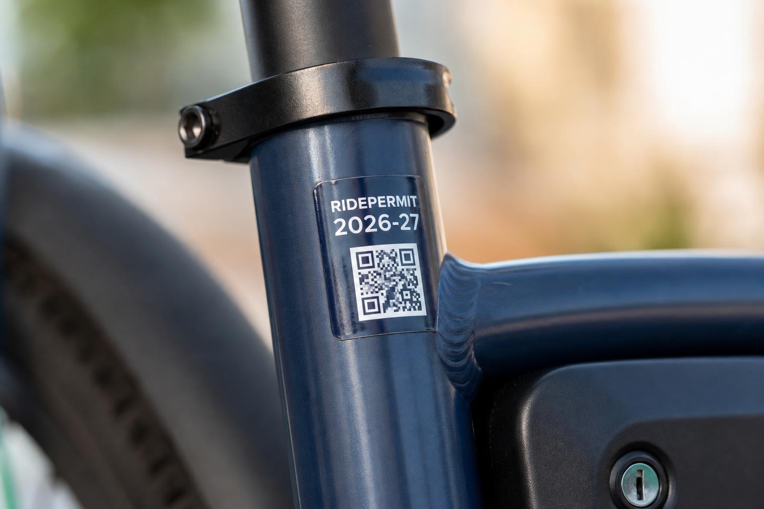 Close-up of a navy RidePermit registration sticker with a QR code, applied to an e-bike frame.
